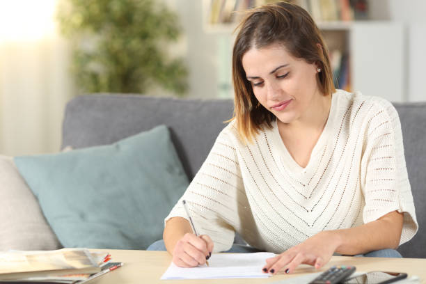 istock Woman taking notes or filling form at home 1191967525