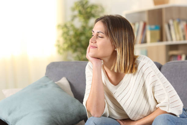 istock Relaxed woman meditating sitting on a couch at home 1191967532