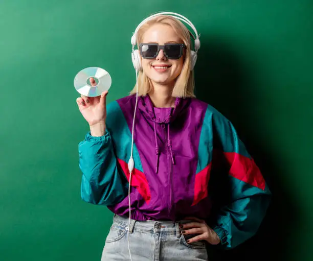 Photo of Style woman in 90s punk clothes with headphones and CD