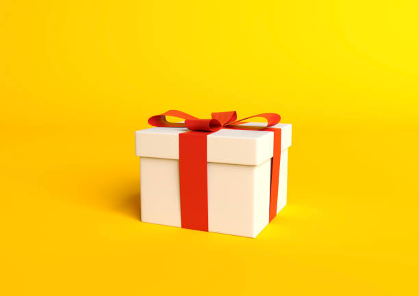 istock White gift box with red ribbon on pastel yellow background 1191971430