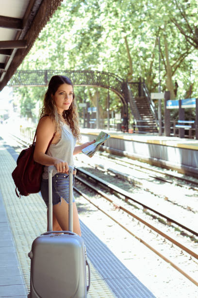 istock Woman with suitcase waiting the train. 1191973313