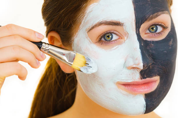 istock Girl black mask on half face apply white mud 1191977397
