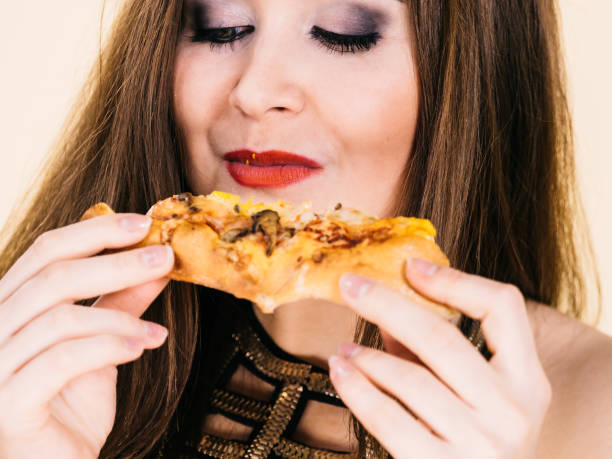 istock Woman eating hot pizza slice 1191978314