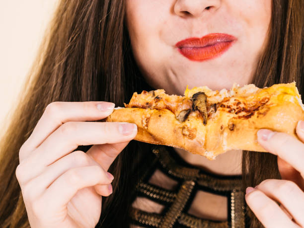istock Woman eating hot pizza slice 1191978628