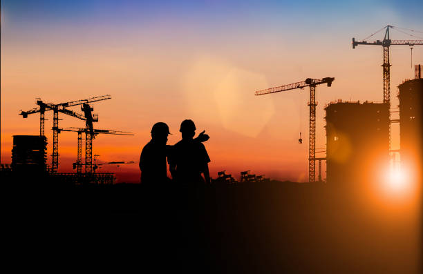 istock Silhouette of Survey Engineer and construction team working at site over blurred  industry background with Light fair Film Grain effect.Create from multiple reference images together 1191983195