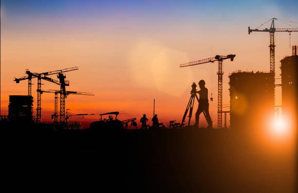 istock Silhouette of Survey Engineer and construction team working at site over blurred  industry background with Light fair Film Grain effect.Create from multiple reference images together 1191983203