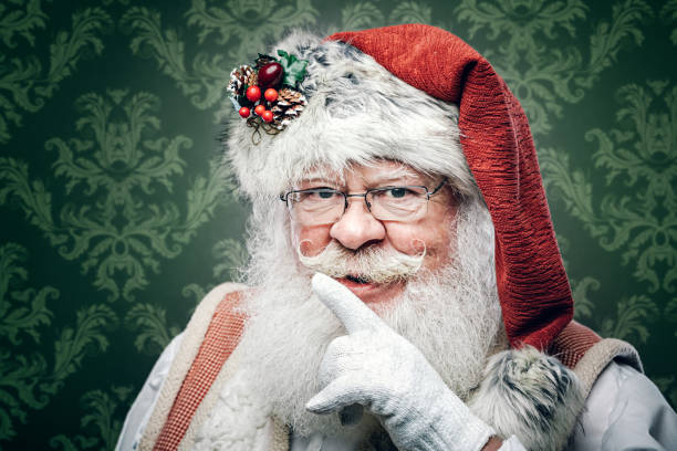 Classic Santa Claus Christmas Portrait A portrait of a traditional Saint Nicholas or Father Christmas figure, wearing festive holiday clothing. santa claus expressions shhh stock pictures, royalty-free photos & images