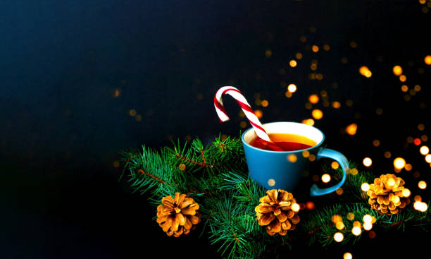 tazza di tè e canna caramellata su una consistenza di rami di pino sullo sfondo della neve che cade. sfondo natalizio. primo piano - falling candy christmas candy cane foto e immagini stock