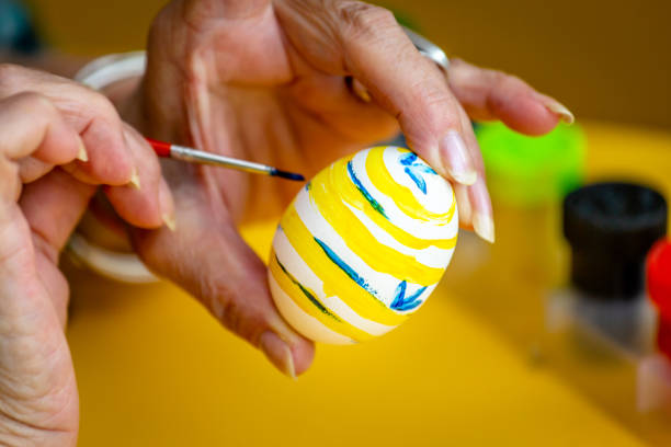 Small quail eggs painted for the easter holidays and a glass of paint.