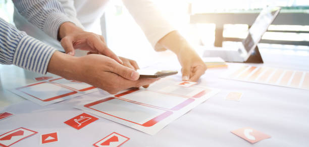 istock Cropped shot of young successful UI graphic developer team working on their smartphone application 1191996591