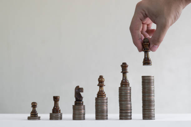 istock Coin stacks arranged with chess pieces into growth chart on white background, finance and business concept, copy space 1191997797