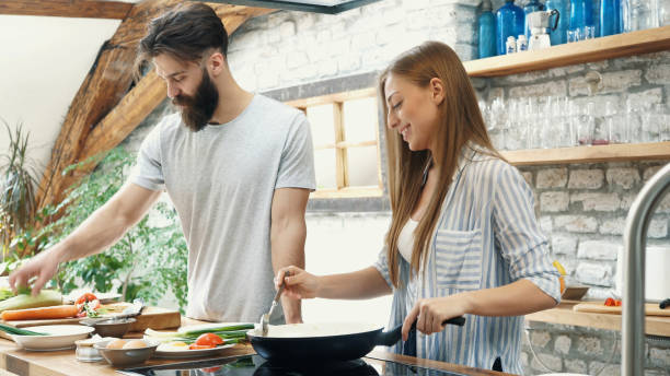 istock Young couple making dinner together at home 1191999632