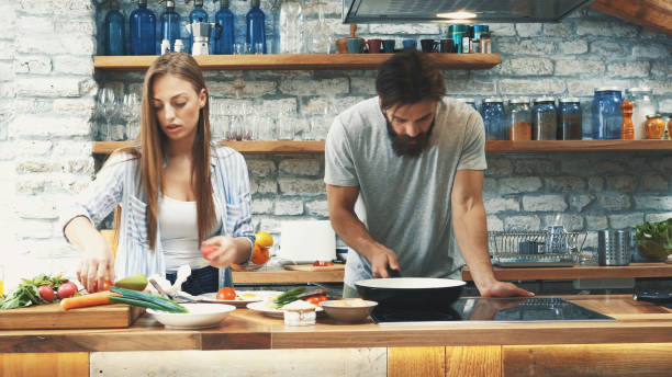 istock Young couple making dinner together at home 1191999633