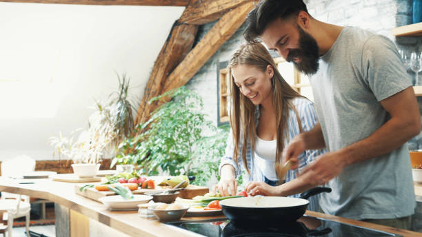 istock Young couple making dinner together at home 1191999635