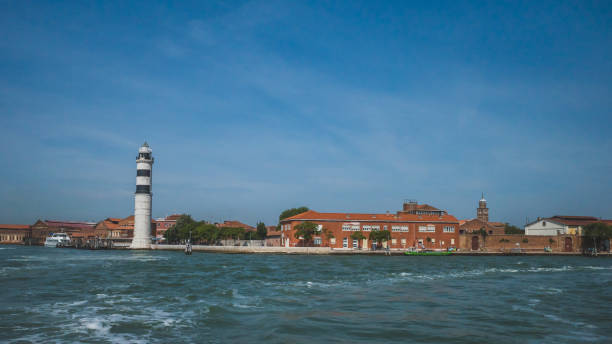 istock Lighthouse and buildings by water, in Murano, Venice, Italy 1192000649