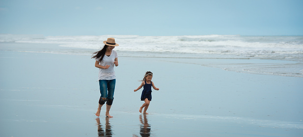 Mother and daughter playing on the beach