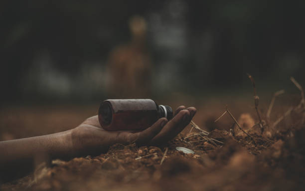 Concept of Farmer Suicide, closeup of hands with poison bottle at farm or agriculture land. Concept of Farmer Suicide, closeup of hands with poison bottle at farm or agriculture land suicide photos stock pictures, royalty-free photos & images