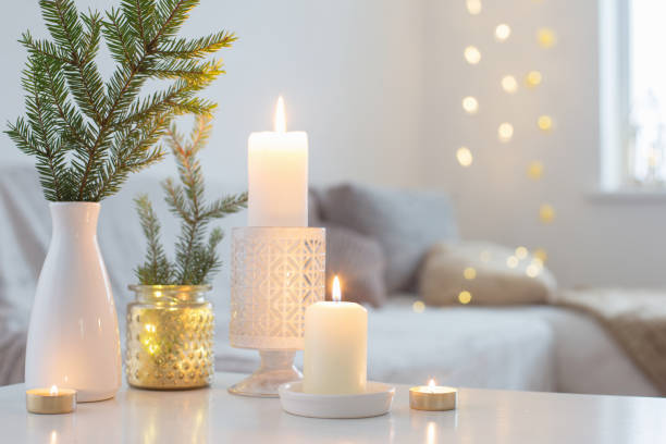 istock Christmas decorations with burning candles in white interior 1192007833