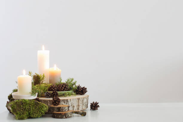 istock burning candles on saw with cones and branches on white background 1192007843