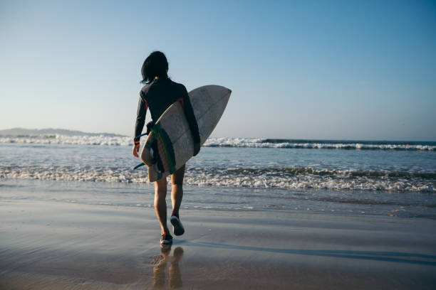 istock Woman surfer with surfboard on beach 1192012824