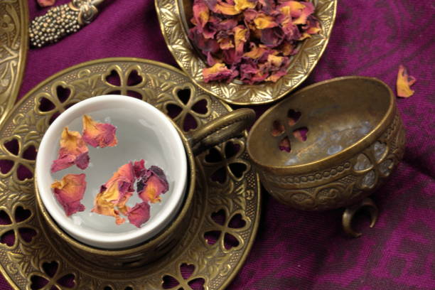 Overhead view of a tea cup of Rose tea with rose petals