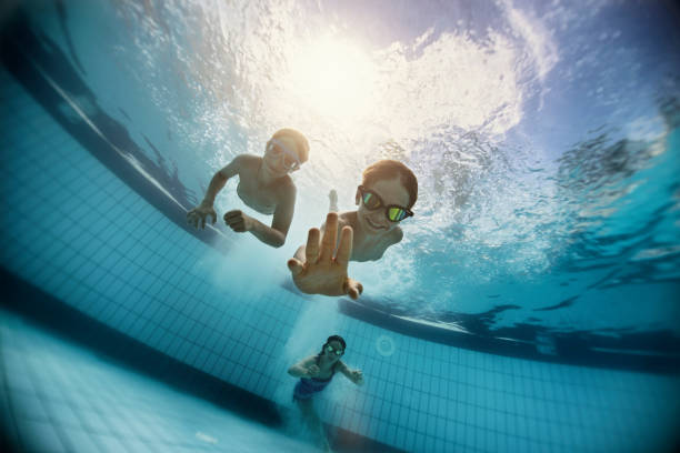 Happy kids swimming underwater in pool