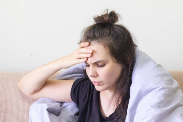 istock Sick young woman sitting at home with severe headache 1192029149