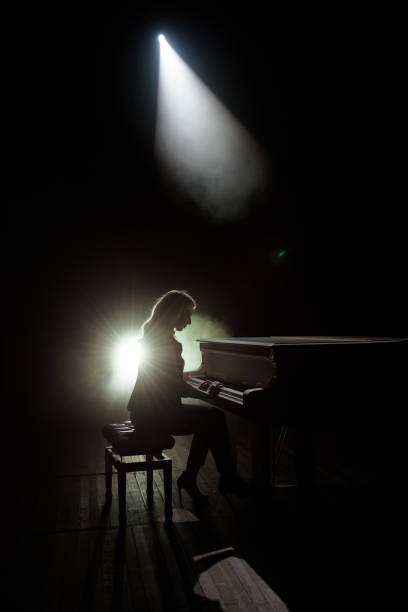 istock Female keyboards player on stage during concert, backlight 1192029818