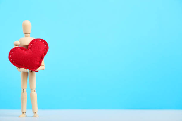 istock Wooden figure with red heart on blue background 1192029821