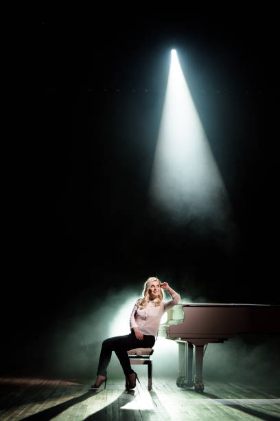 istock Pianist posing near white piano on the stage 1192029874