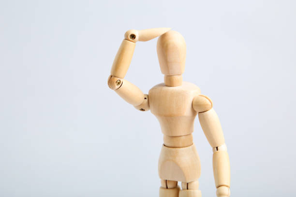 istock Wooden figure having headache on gray background 1192029903