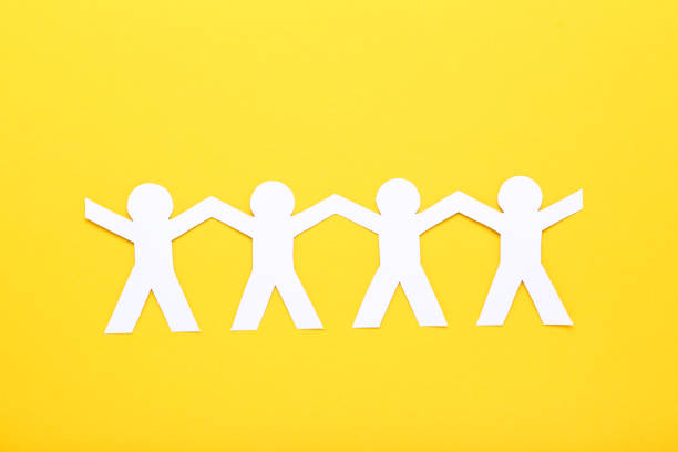 istock Paper chain people on yellow background 1192032082