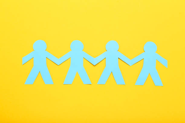 istock Paper chain people on yellow background 1192032096