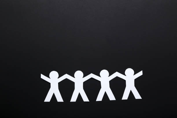 istock Paper chain people on black background 1192032613