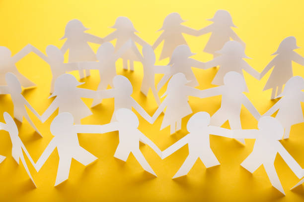 istock Paper chain people on yellow background 1192033148