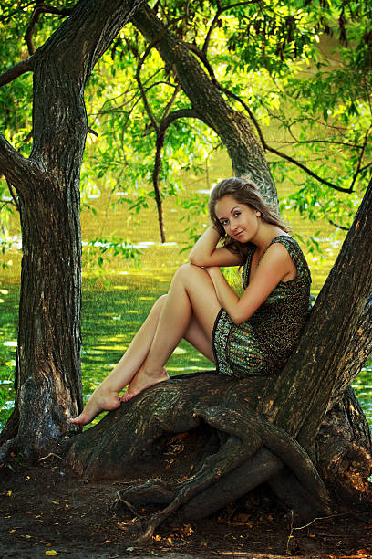 istock beautiful girl sitting on a large tree 119203483