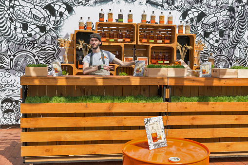 KYIV, UKRAINE - MAY 18, 2019: Bartender works at Bulleit Bourbon frontier whiskey booth during Kyiv Beer Festival vol. 4 in Art Zavod Platforma. It is a brand of Kentucky straight bourbon whiskey.