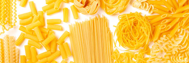 istock Italian pasta texture panoramic flatlay banner, overhead shot on a white background. Fusilli, farfalle, spaghetti, penne, rigatoni and other sorts 1192038696