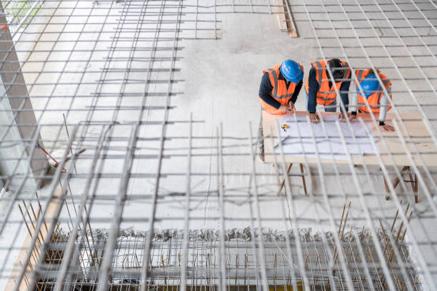 istock Foreman and forewoman discussing blueprint with architect 1192041846