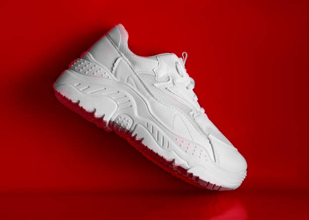 istock Beautiful white sneakers on a red background. 1192042183