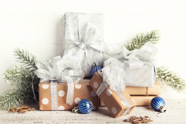 istock Gift boxes with ornaments and fir tree branches on white wooden background 1192042823