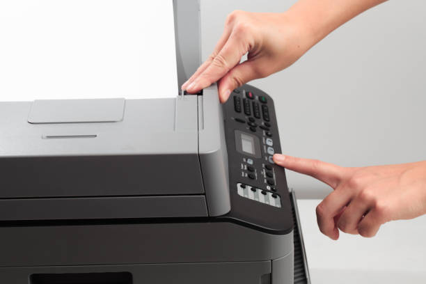 istock Hand press button on panel of printer. printer scanner laser office copy machine supplies start concept 1192045373
