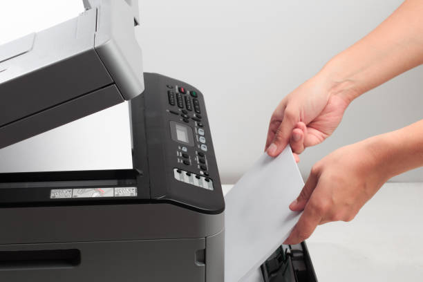 istock Hand press button on panel of printer. printer scanner laser office copy machine supplies start concept 1192045377