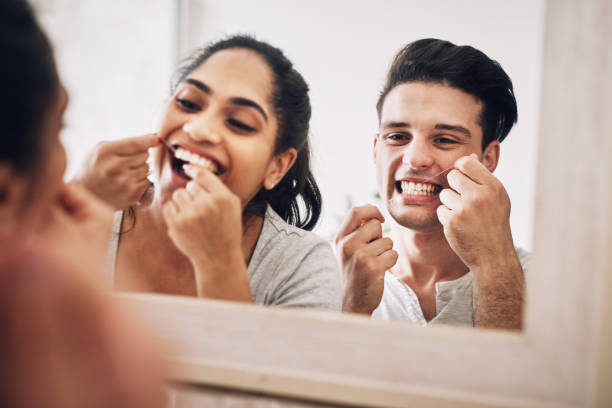 Our love shines as bright as our teeth Cropped shot of a young couple flossing their teeth together dental floss stock pictures, royalty-free photos & images