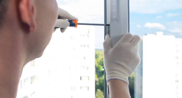 istock master in gloves, with a screwdriver, repairs the plastic window 1192049550