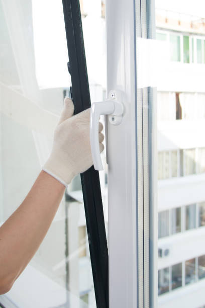 istock the hand of the master in protective gloves, changes the double-glazed window in a plastic window 1192049576