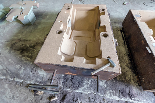 View of the large sand mould of the steel valve for metal casting. Sand casting, also known as sand molded casting, is a metal casting process characterized by using sand as the mold material.