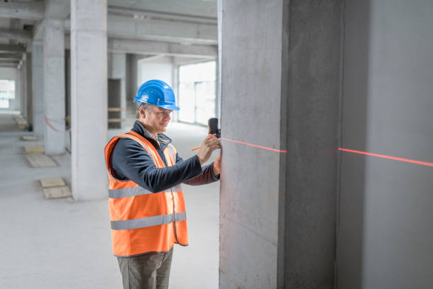 Construction worker measuring support beam Male construction worker measuring concrete support beam with laser spirit level at site. spirit level stock pictures, royalty-free photos & images