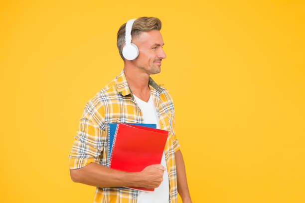 istock Another way of study. Man handsome college student headphones books. Study languages. Learning english. Educational technology. Study. Audio book concept. Worldwide knowledge access. Audio library 1192053142