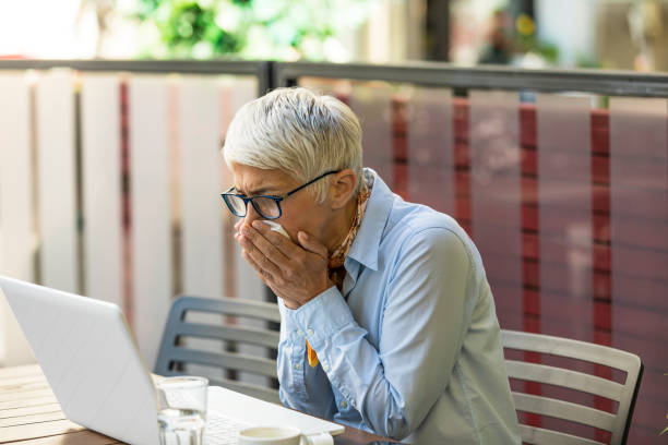 istock Older Woman with Allergic Problems is Using Paper Handkerchiefs to Blow her Nose 1192053372